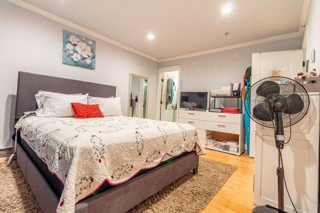 bedroom featuring ornamental molding and light hardwood / wood-style floors