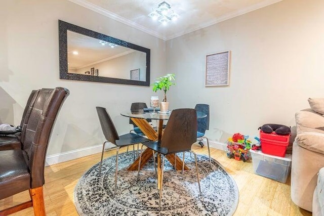 dining space with crown molding and hardwood / wood-style floors