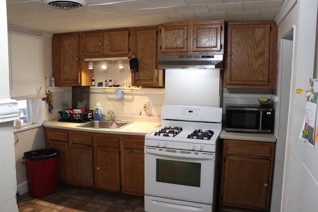 kitchen with sink, tile flooring, and white range with gas cooktop