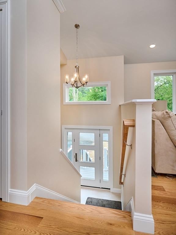 foyer featuring a chandelier, wood finished floors, and baseboards