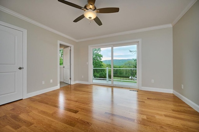 spare room featuring light wood-type flooring, crown molding, ceiling fan, and baseboards