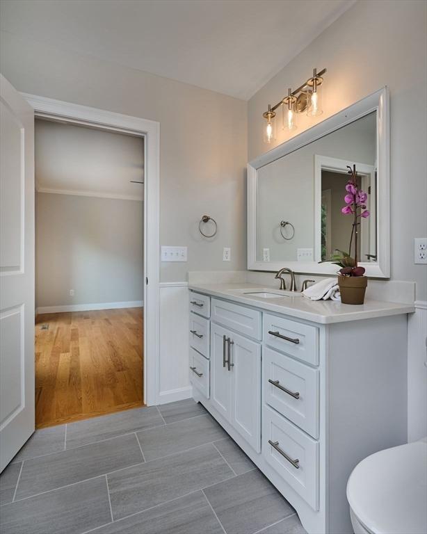bathroom with vanity, toilet, and ornamental molding