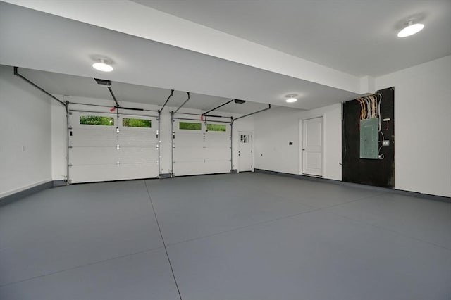 garage featuring electric panel and baseboards