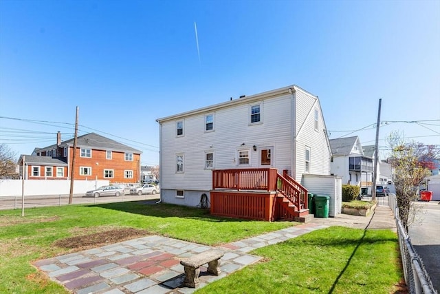 rear view of property featuring a lawn, a residential view, fence, and a wooden deck