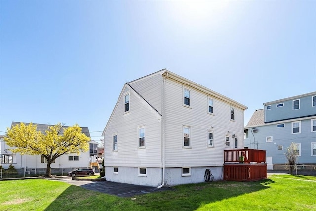 back of property featuring a lawn and fence