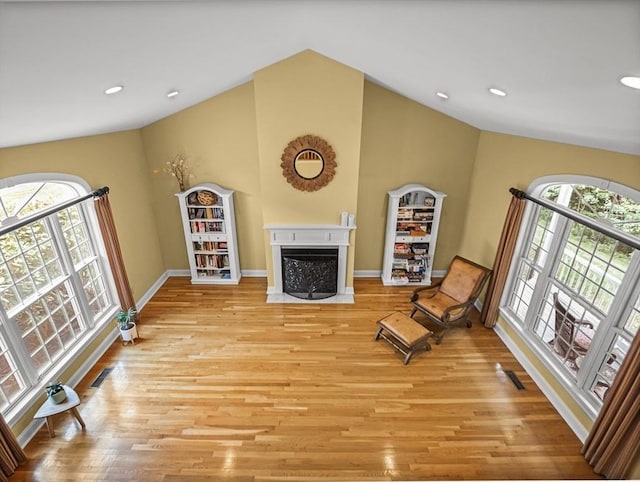 455 Brockelman Rd, Lancaster, MA 01523 - sitting room featuring plenty of natural light, a fireplace with flush hearth, light wood finished floors, vaulted ceiling, and recessed lighting