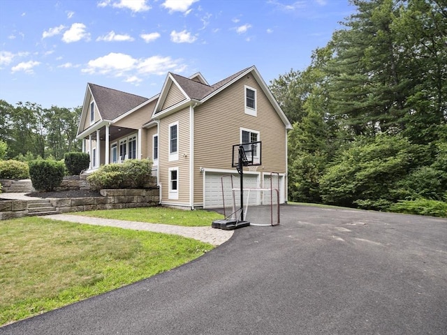 455 Brockelman Rd, Lancaster, MA 01523 - view of side of home with an attached garage, asphalt driveway, and a lawn