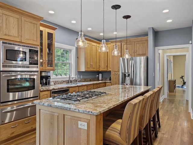 455 Brockelman Rd, Lancaster, MA 01523 - kitchen featuring stainless steel appliances, a warming drawer, a center island, light stone countertops, and glass insert cabinets