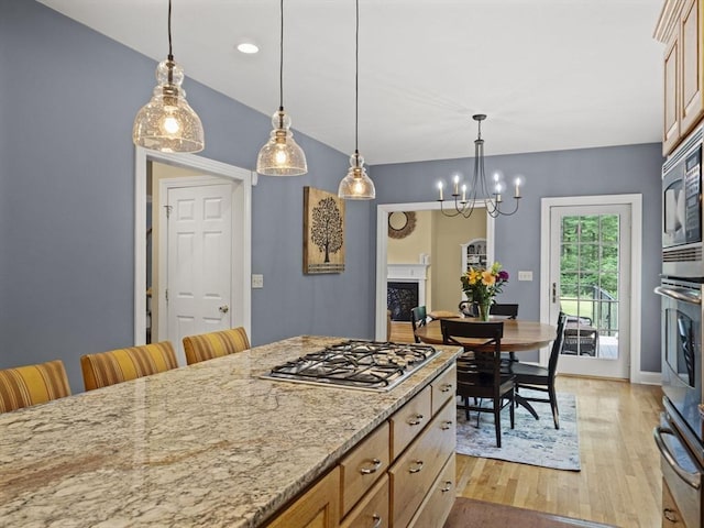 455 Brockelman Rd, Lancaster, MA 01523 - kitchen with a warming drawer, appliances with stainless steel finishes, light wood-style flooring, hanging light fixtures, and light stone counters