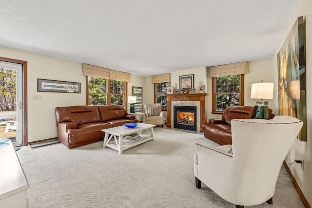 living room featuring a fireplace with flush hearth, carpet, a healthy amount of sunlight, and a textured ceiling