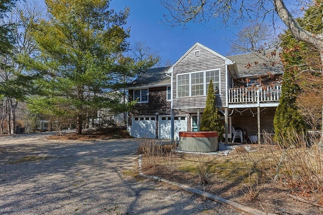 exterior space with a garage, driveway, and a hot tub