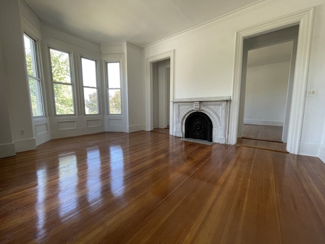 unfurnished living room featuring ornamental molding and hardwood / wood-style flooring