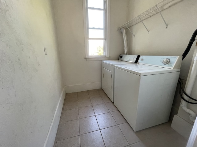 washroom featuring light tile patterned flooring and washing machine and clothes dryer