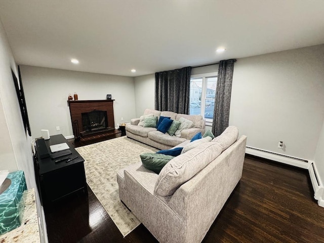 living room featuring wood finished floors, recessed lighting, baseboards, and a brick fireplace