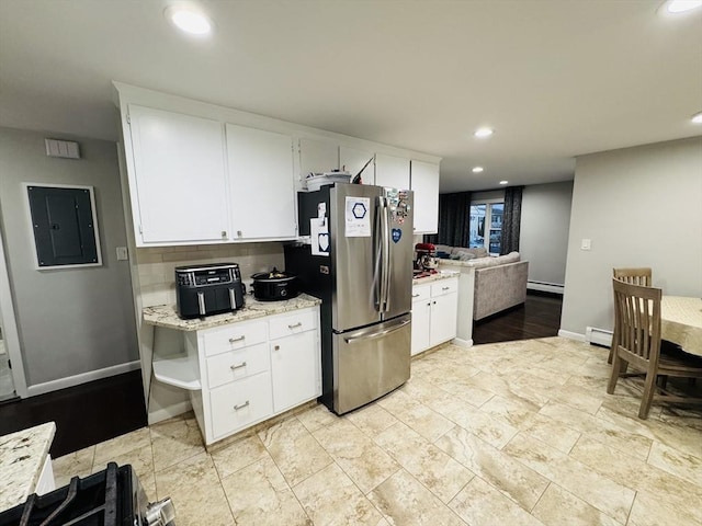 kitchen featuring freestanding refrigerator, electric panel, a baseboard radiator, recessed lighting, and white cabinetry
