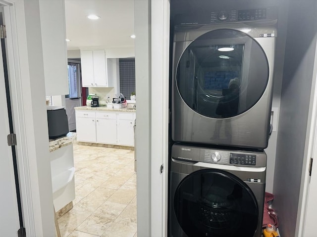 laundry area featuring stacked washer / drying machine and recessed lighting