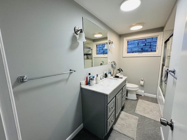 full bath featuring toilet, baseboards, vanity, and bath / shower combo with glass door