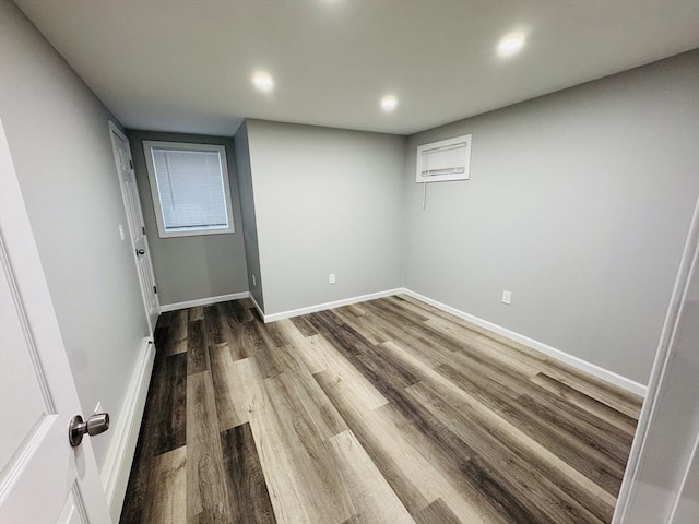 spare room featuring wood finished floors, recessed lighting, and baseboards