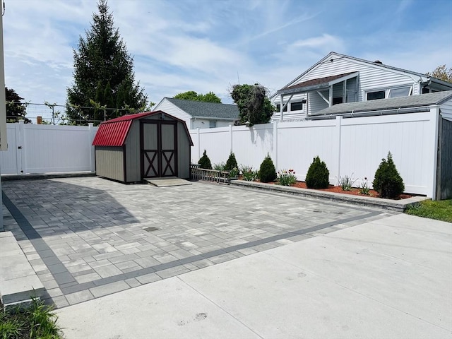 view of patio / terrace featuring a storage unit, a fenced backyard, and an outbuilding