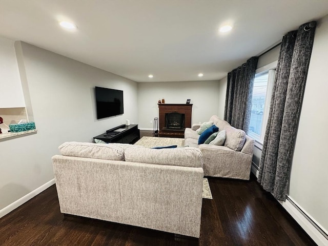 living area with a baseboard radiator, a fireplace, dark wood-style floors, recessed lighting, and baseboards