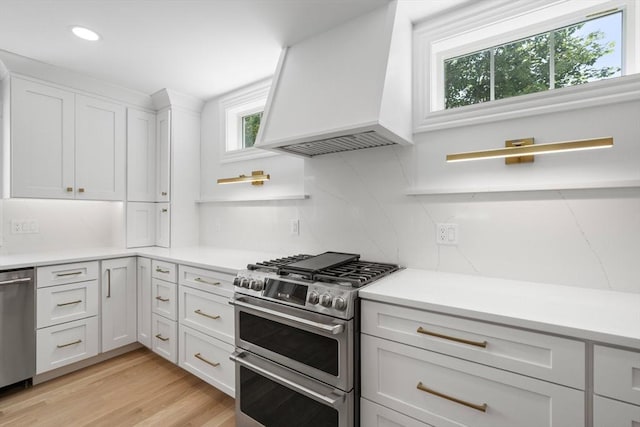 14 Norman Ave, Newburyport, MA 01950 - kitchen with appliances with stainless steel finishes, premium range hood, white cabinetry, recessed lighting, and light countertops