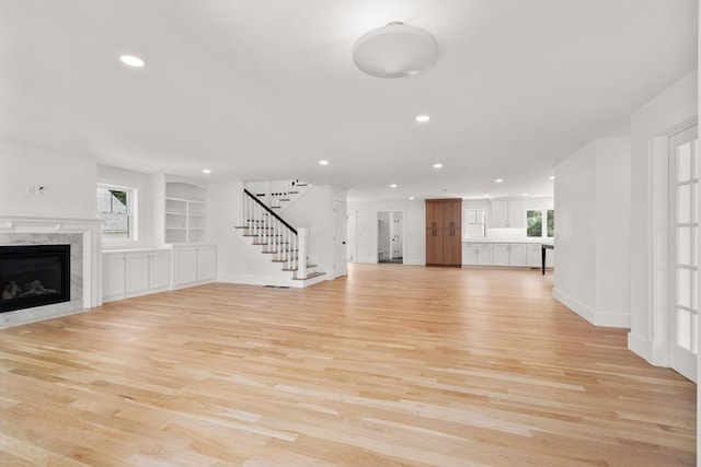 14 Norman Ave, Newburyport, MA 01950 - unfurnished living room featuring stairway, light wood finished floors, recessed lighting, a high end fireplace, and built in features