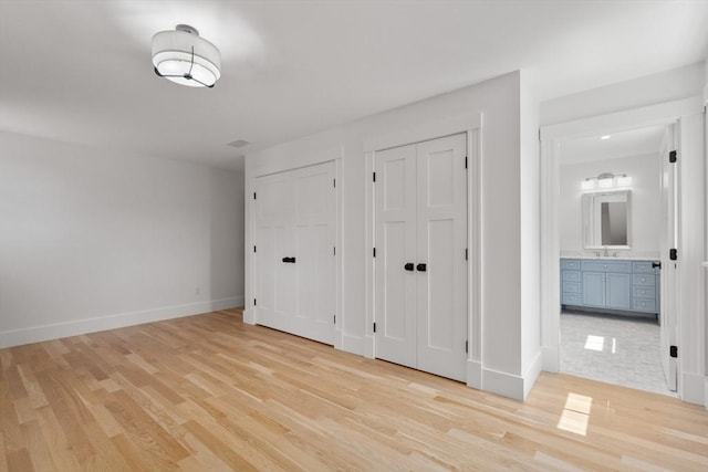 14 Norman Ave, Newburyport, MA 01950 - unfurnished bedroom featuring multiple closets, light wood-style floors, and ensuite bath