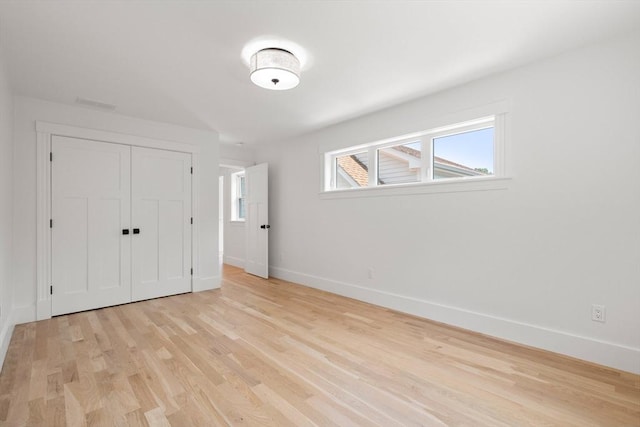 14 Norman Ave, Newburyport, MA 01950 - unfurnished bedroom featuring multiple windows, light wood-style flooring, and a closet