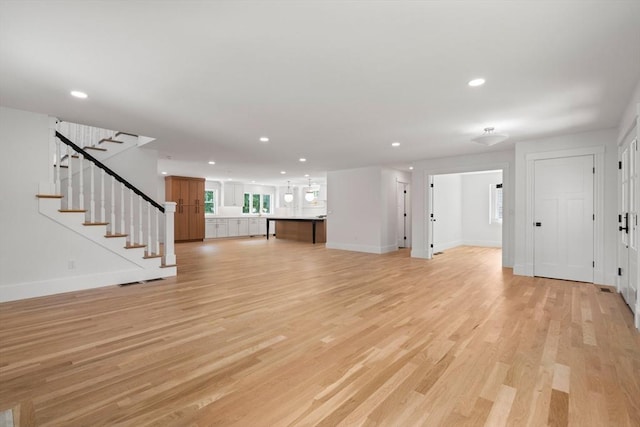 14 Norman Ave, Newburyport, MA 01950 - unfurnished living room with light wood finished floors, recessed lighting, and stairway