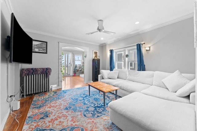 92 Winthrop Shore Dr Unit 2, Winthrop, MA 02152 - living room with arched walkways, radiator, ceiling fan, wood finished floors, and ornamental molding
