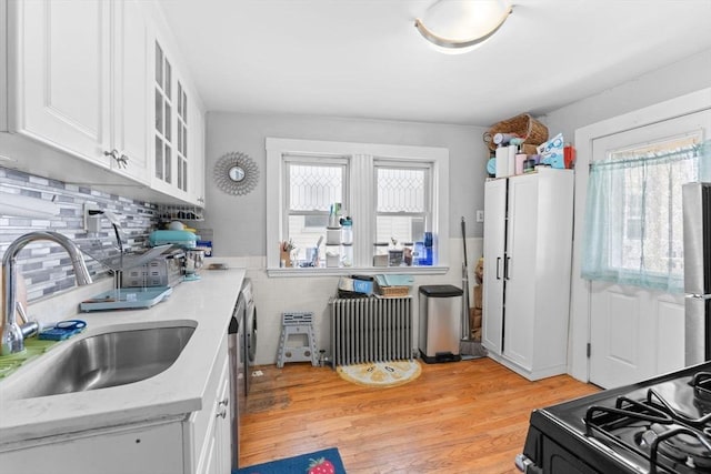 92 Winthrop Shore Dr Unit 2, Winthrop, MA 02152 - kitchen with a sink, black range with gas stovetop, white cabinetry, glass insert cabinets, and light wood finished floors