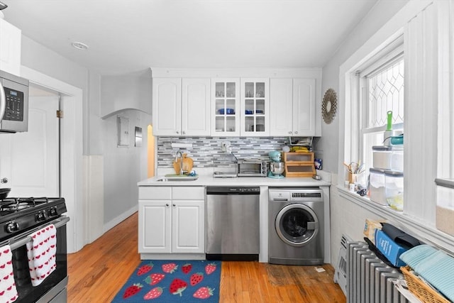 92 Winthrop Shore Dr Unit 2, Winthrop, MA 02152 - kitchen featuring washer / dryer, appliances with stainless steel finishes, light countertops, white cabinets, and a sink