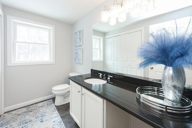 full bathroom featuring double vanity, a wealth of natural light, toilet, and a sink