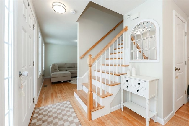 stairway featuring baseboards and hardwood / wood-style floors