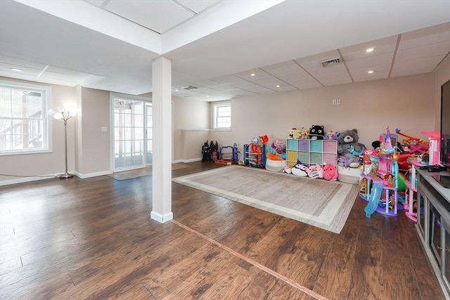 playroom featuring dark wood-style floors, a paneled ceiling, recessed lighting, visible vents, and baseboards