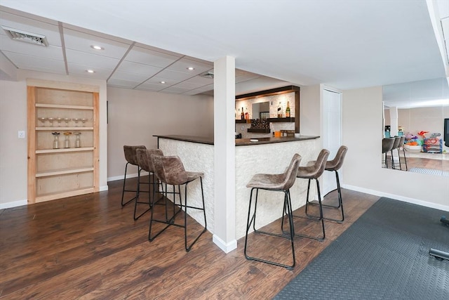 bar with dark wood-style floors, baseboards, visible vents, and a dry bar