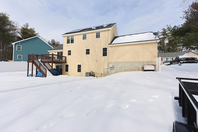 snow covered rear of property with stairs, central AC, and a wooden deck