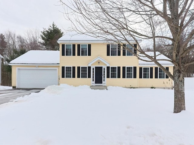 colonial-style house featuring a garage, entry steps, and aphalt driveway