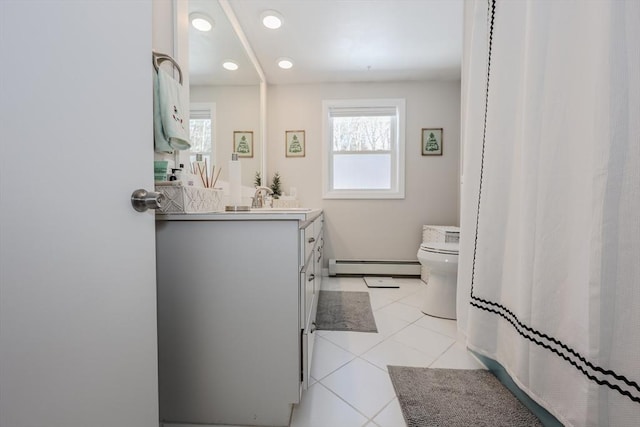 bathroom with a baseboard radiator, tile patterned flooring, a healthy amount of sunlight, and toilet