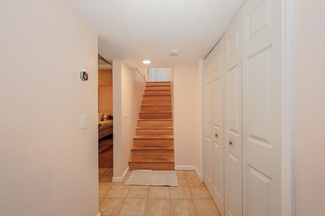 stairs with baseboards and tile patterned floors