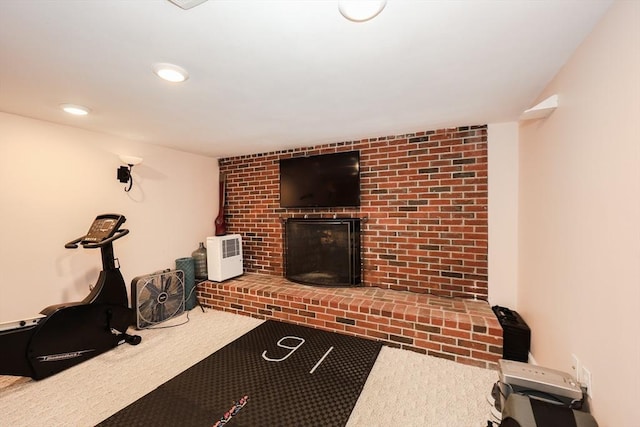 workout room featuring recessed lighting, carpet flooring, and a fireplace