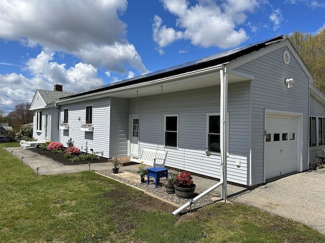 rear view of house featuring a garage, a lawn, and entry steps