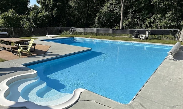 view of swimming pool featuring a diving board, a patio, a fenced backyard, and a fenced in pool