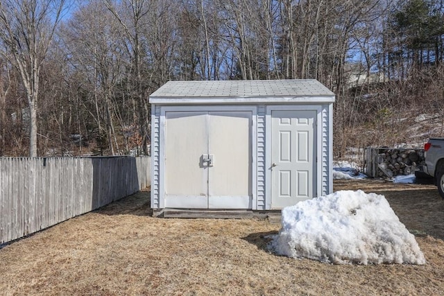 view of shed featuring fence