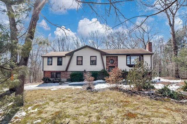 view of front of home with brick siding, a gambrel roof, and a chimney