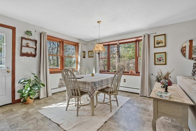 dining space featuring a textured ceiling and baseboard heating