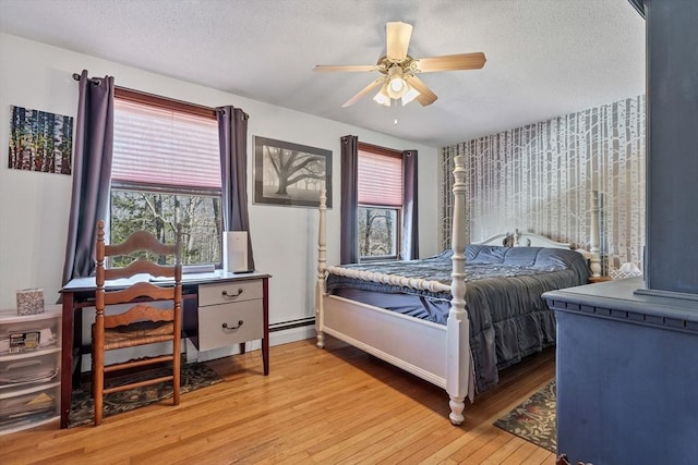 bedroom with a ceiling fan, light wood-style floors, and a textured ceiling