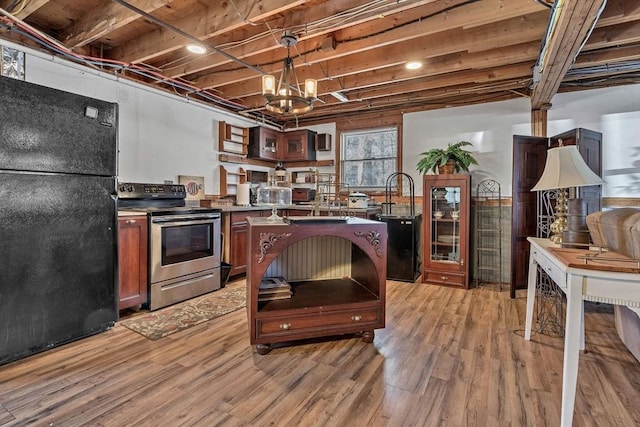 kitchen with a chandelier, light wood-style flooring, stainless steel electric range, and freestanding refrigerator