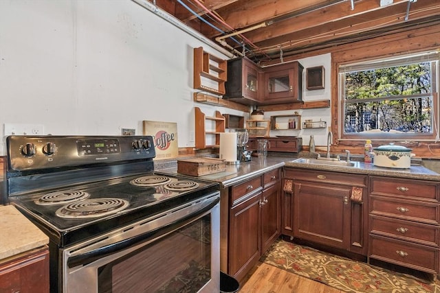 kitchen with light wood-style flooring, electric range oven, and a sink