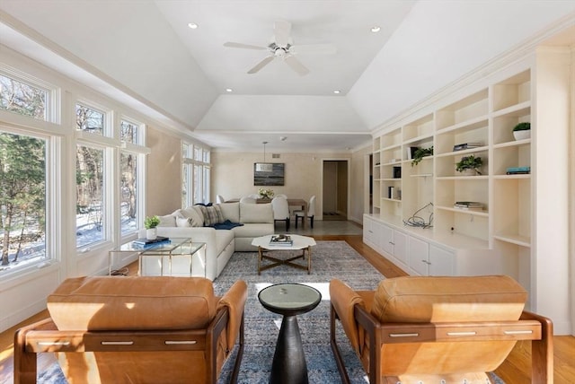 living room with built in shelves, ceiling fan, vaulted ceiling, and light hardwood / wood-style floors